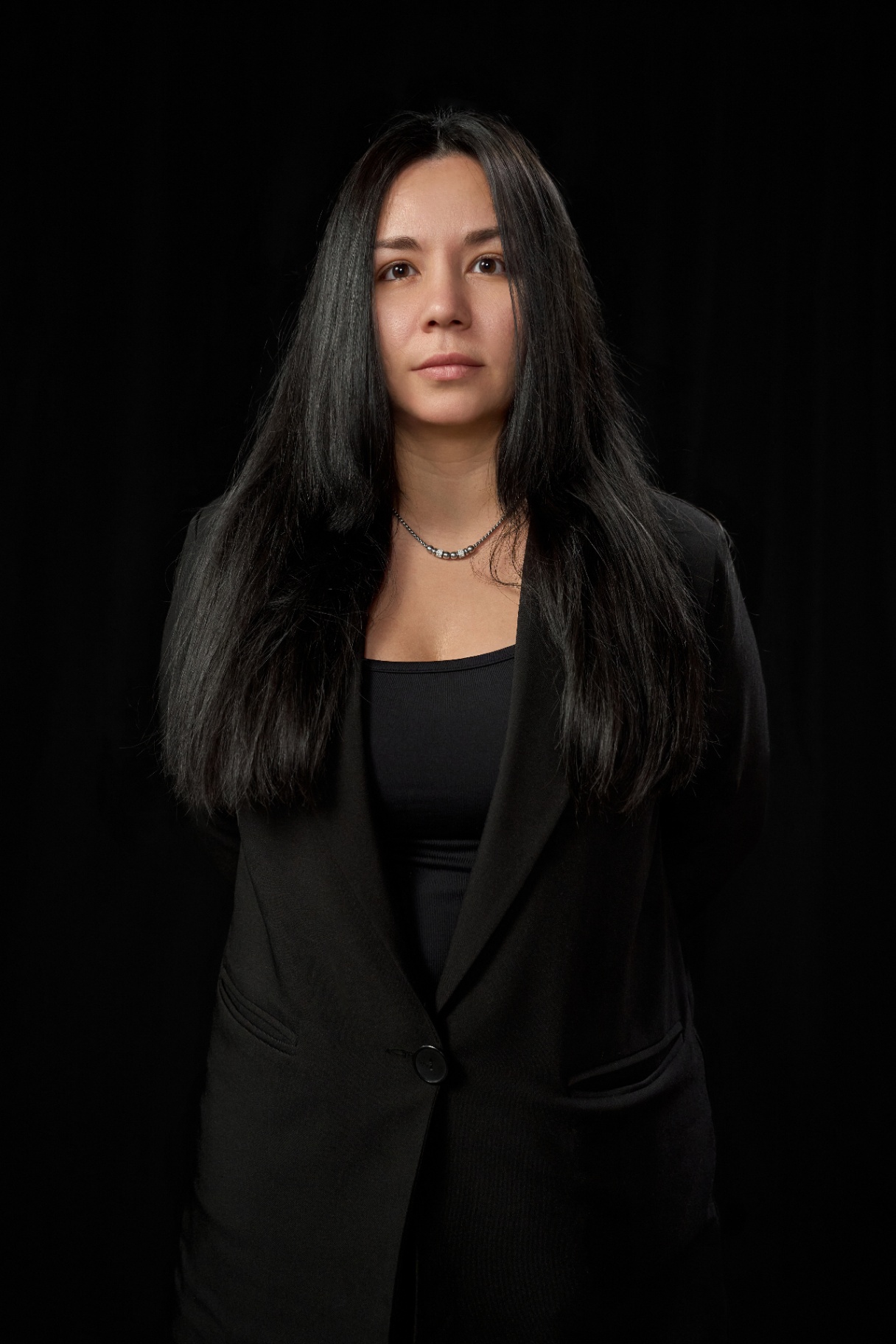 Modella con capelli neri in blazer nero durante il backstage